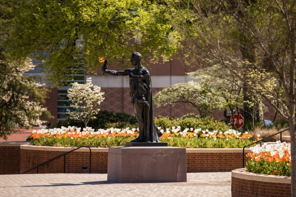 The Torchbearer Statue stands tall as spring flowers bloom in Circle Park